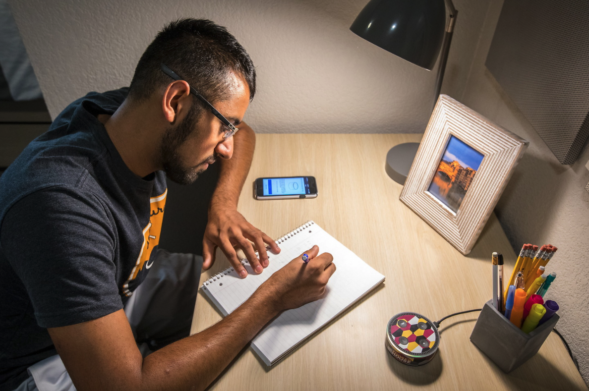 Student writing at desk